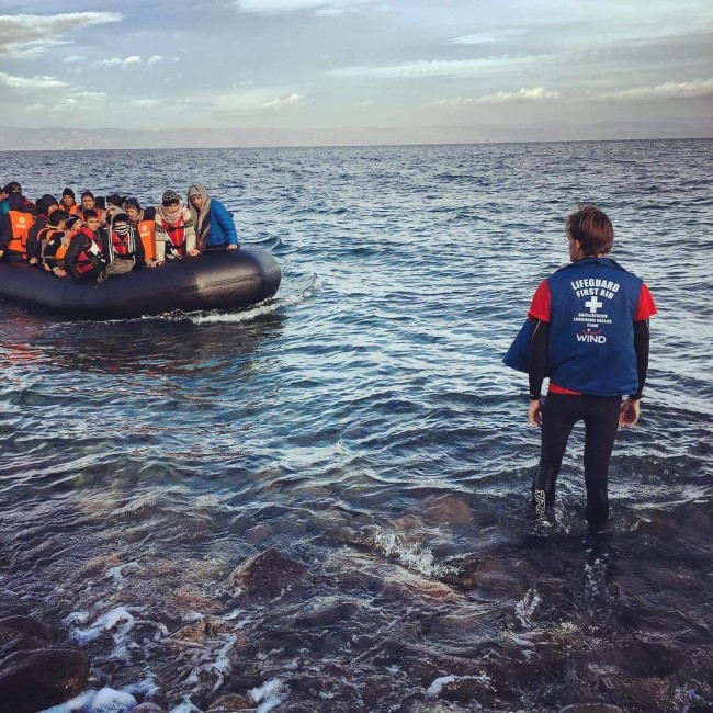 ISLA Volunteer Caleb Scott guiding in a boat of refugees on the coast of Lesvos.